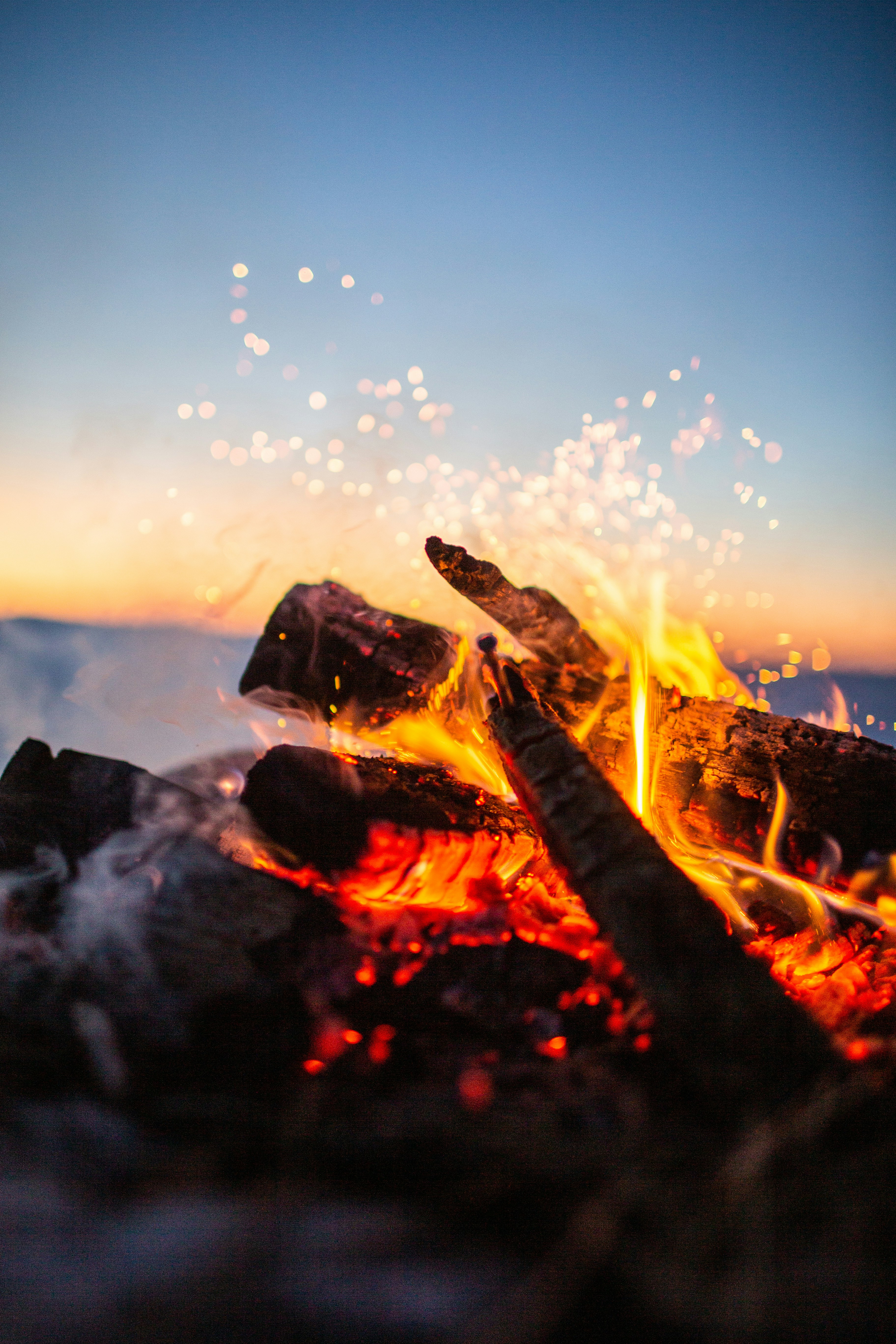 Lagerfeuer mit Funken in der Abenddämmerung