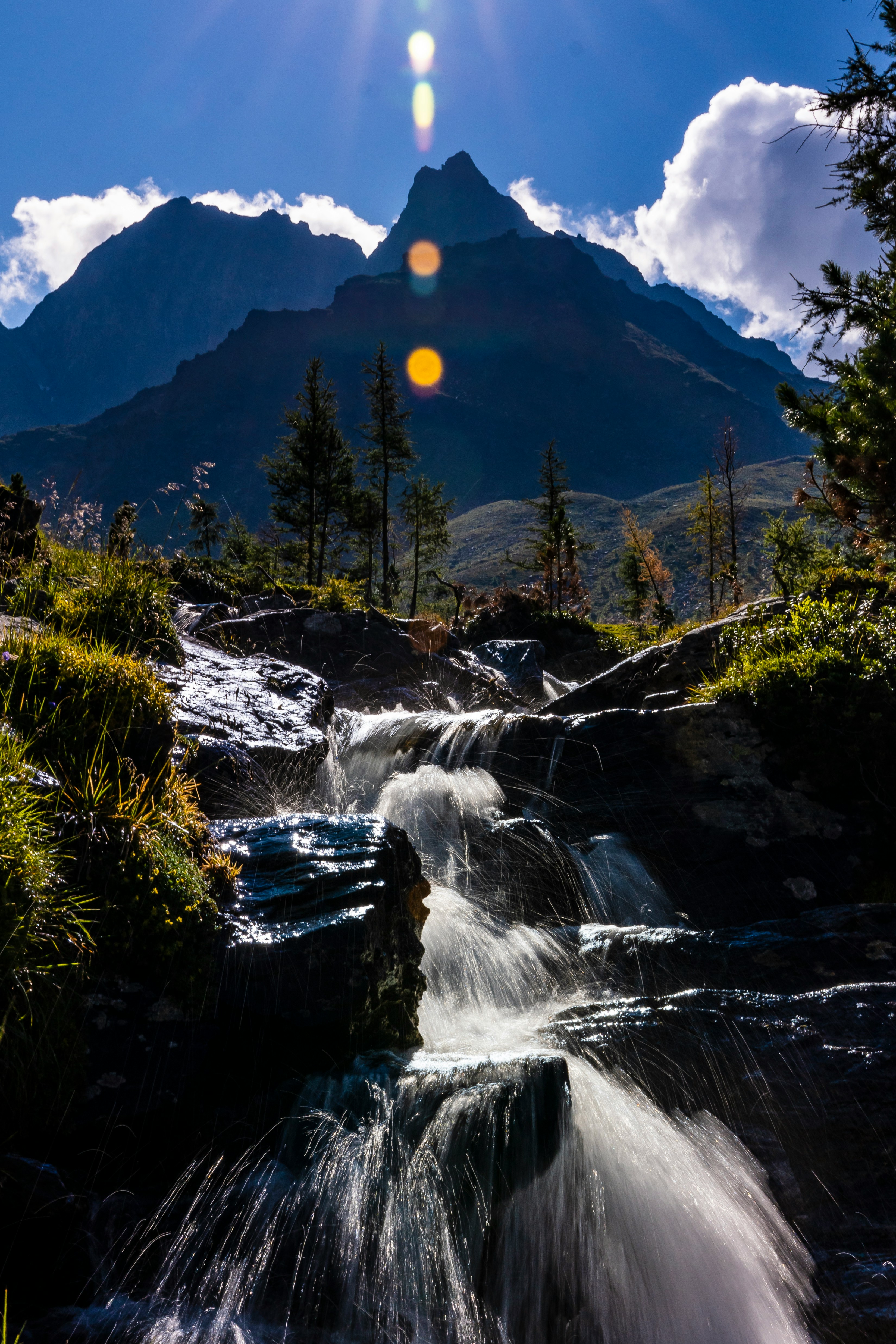 Wasserfall über Felsstufen vor Berggipfel